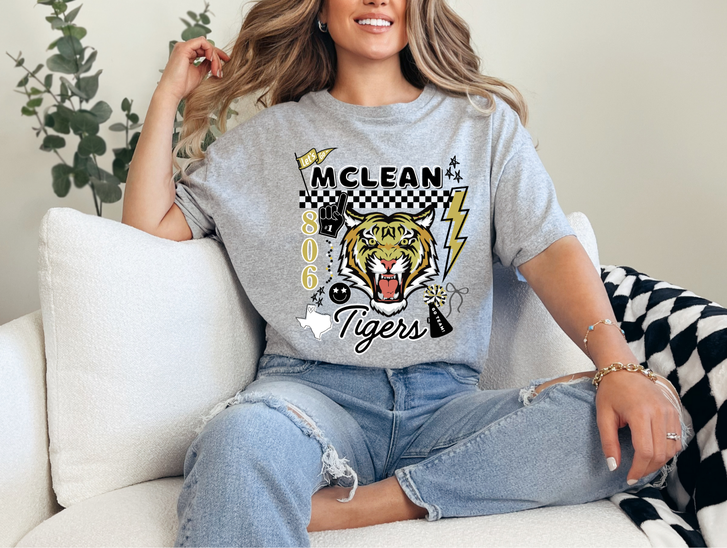 Person wearing a gray t-shirt with 'MCLEAN 806 Tigers' design, sitting on a couch.