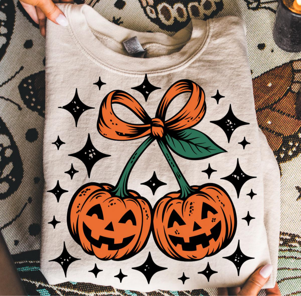Gray sweatshirt with Halloween-themed design featuring pumpkins and a bow.