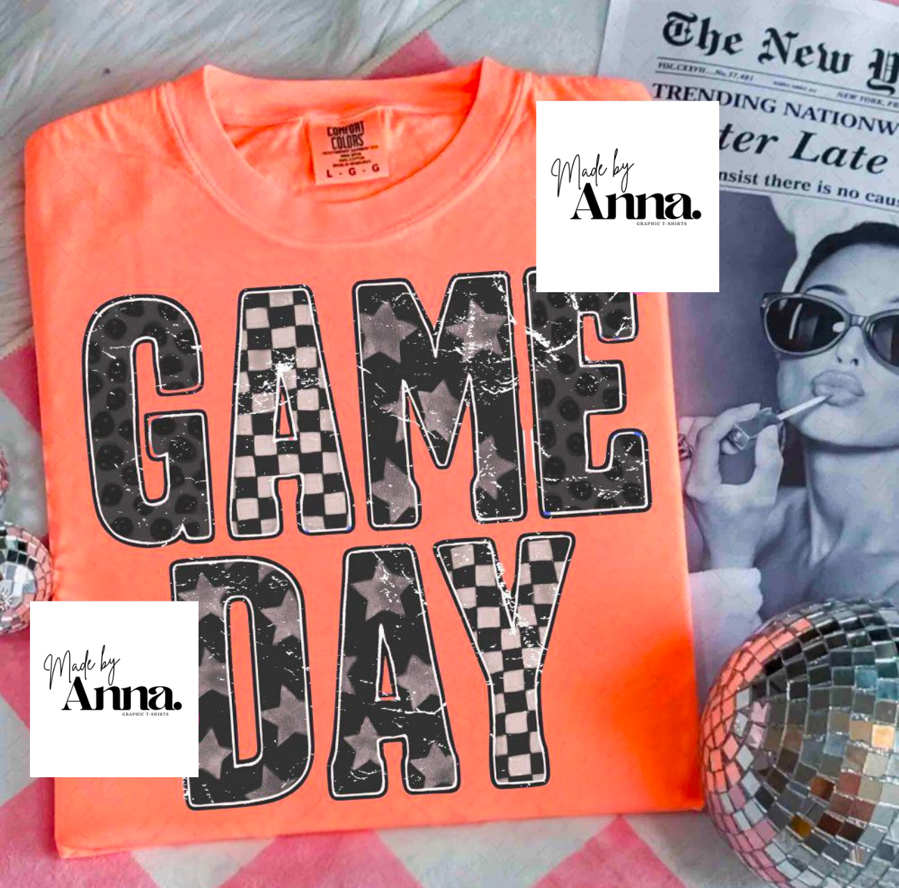 Neon orange t-shirt with 'GAME DAY' text on a surface with a magazine and disco ball.
