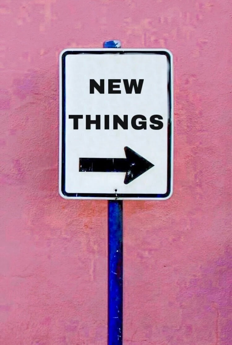 Street sign with 'NEW THINGS' text and arrow on a pink background